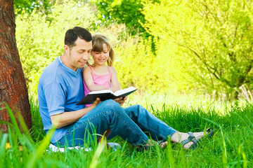 Poster - young father with a small daughter reading the Bible