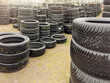 Used tires. Sale of used tires, stacks of different car tires lie on the ground. Buying used tires is a cheap alternative to new
