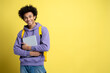 © Maria Vitkovska - Confident smiling African American student holding laptop isolated on yellow background, copy space. Education concept. Portrait of happy successful man freelancer looking at camera