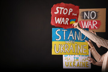 Wall Mural - Stop war in Ukraine. People holding posters on black background, space for text