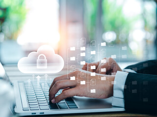 Cloud technology concept. Cloud icons with folders and document files showing on screen while businessperson working with laptop computer. Data storage security, digital privacy secure on internet.