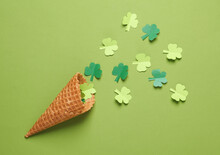 St.Patrick 's Day. Paper-cut Clover Leaves In Waffle Cone On Green Background. March 17. Flat Lay. Top View