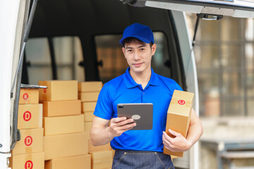 Delivery man asia people checking portable delivery device with parcel box to customer home address. Using tablet pc computer technology