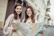 © splitov27 - Two smiling young women tourist exploring the city map on a european street. Travel together. Two lovely female friend