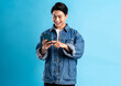 © STOCK88PHOTOGRAPHER - Young asian man using phone on a blue background