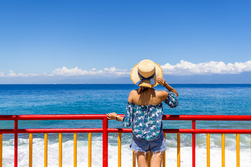 Poster - Tourist woman look at the beautiful sea and sky