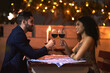 © R Jordaan/peopleimages.com - Love, wine and toast of couple on date for fine dining, restaurant or night valentine celebration together. Happy black woman with romance partner alcohol glass, celebrate and luxury in night bokeh