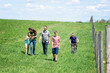 © Cavan Images - Family of five walking in a field in the country.