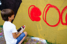 Boy Drawing Graffiti On The City Wall