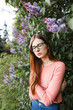 © Cavan Images - young brown-haired woman in glasses and a sweater in a spring park