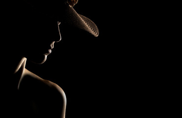 Wall Mural - Sensual portrait silhouette of beautiful woman with a hat in backlight on a black background