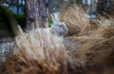 Wall Mural - Easter greetings - Easter bunny rabbit sitting in green grass in garden.