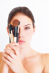 Sticker - Woman, face and makeup brush in hands, portrait and beauty with cosmetics isolated on white background. Cosmetology, female in studio with cosmetic tools and skincare, dermatology glow and wellness