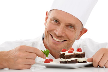 Wall Mural - Bakery, baking and portrait of a chef with cake presentation isolated on a white background in a studio. Fruit, food and face of a professional baker with a sweet chocolate dessert for catering