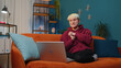 © Andrii Iemelianenko - Young woman with short hair sitting on couch looking at camera, making video webcam conference call with friends or family, enjoying pleasant conversation. Girl laughing waving hello at night home