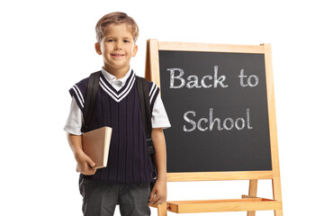 Canvas Print - Schoolboy standing in front of a chalk board with text back to school