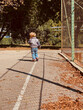 © Cavan - boy 2 years old walking near the basketball court
