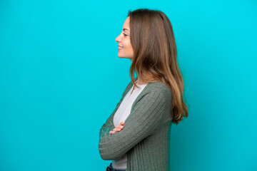 Wall Mural - Young caucasian woman isolated on blue background in lateral position