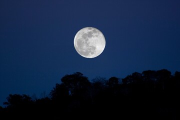 full moon rising from the mountains