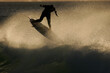 A surfer executes a radical aerial move as he surfs a wave in the ocean. at dawn