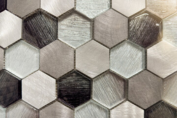 Buying wall tiles from a hardware store. Beautiful glass and metal mosaic, hexagonal honeycomb imitation mosaic elements, sample tiles in black and gray in a hardware store.