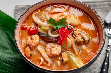 Canvas Print - Spicy Asian tom yum soup with shrimp, squid, mussels and vegetables. Asian cuisine.