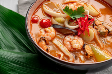 Canvas Print - Spicy Asian tom yum soup with shrimp, squid, mussels and vegetables. Asian cuisine.