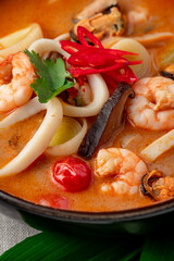 Canvas Print - Spicy Asian tom yum soup with shrimp, squid, mussels and vegetables. Asian cuisine.