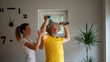 © Gajus - Physiotherapist working with a cheerful senior man teaching him to exercise with dumbbells