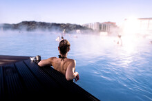 Young Woman Enjoying A Relaxing Bath In The Famous Thermal Bath Blue Lagoon In Iceland.