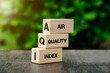 © surasak - AQI Abbreviation of air quality index text on wooden cubes on nature background.