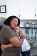 © Vergani Fotografia - Small grandson and grandmother hug each other in the kitchen at home