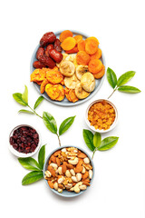 Wall Mural - Dried fruits and nuts, branch with young green leaves on white background . Concept of the Jewish holiday Tu Bishvat. Copy space