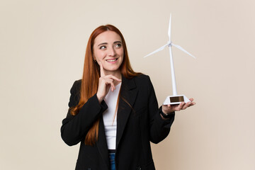 Young business woman holding a windmill, clean energy concept