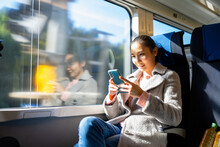 Portrait Of Happy Asian Woman Enjoy City Lifestyle Travel Japan On Train In Autumn Holiday Vacation. Businesswoman Using Mobile Phone With Wireless Technology Working Or Texting Message In The Train.