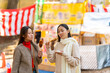 © CandyRetriever  - Asian woman friends eating street food and dessert together while travel outdoor festival at park in autumn holiday vacation. Attractive girl enjoy and fun travel at street market in Tokyo city, Japan