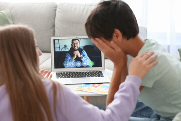 Wall Mural - Upset little boy and his mother video chatting with psychologist at home