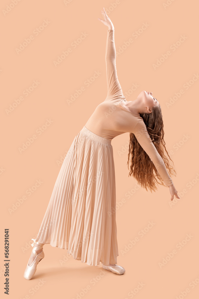 Young ballerina dancing on beige background