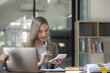© SOMKID - Happy excited young successful business woman and working online at the table in office, Asian business woman.