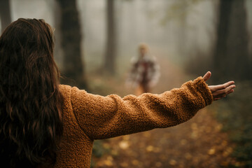 Two happy people are about to hug during outdoor activity. Focus on the woman with spread hands.