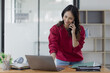 © SOMKID - young asian business woman sitting and laptop in office workplace, business accounting and financial planning concept.