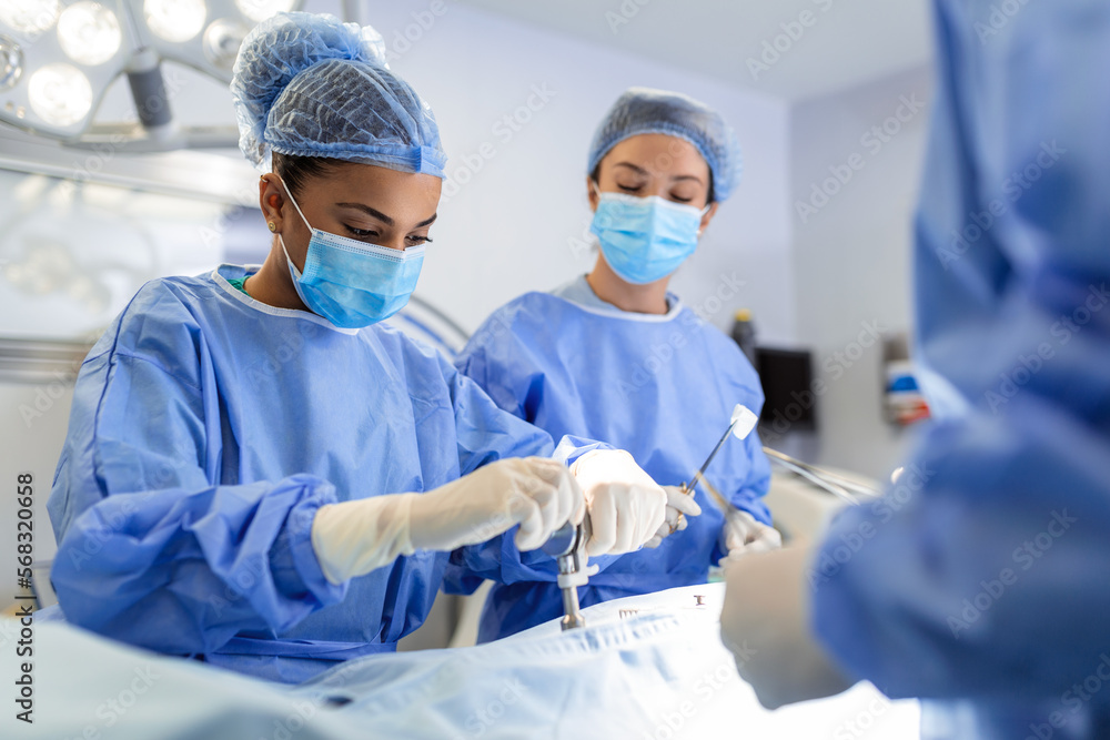 Concentrated female surgeon performing surgery with her team in ...