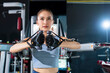 © whyframeshot - closeup sport asia young fitness woman execute exercise with exercise-machine Cable Crossover in gym,Sporty woman exercising on multistation at gym for arm and shoulders muscles. Fitness exercising