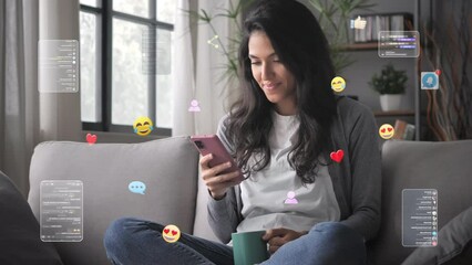 Young woman on couch uses smartphone,graphic representation of social media emoticons ,posts,likes,smiley faces flying around device,3d icons animation visualization