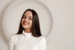 © primipil - Indoor portrait of positive smiling brunette young woman on white background with circle copy space.