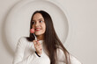© primipil - Indoor portrait of positive smiling brunette young woman on white background holding sweet dessert cake in hands.