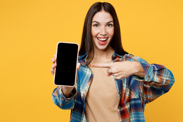 Wall Mural - Young surprised fun woman wearing blue shirt beige t-shirt hold in hand use mobile cell phone blank screen workspace area isolated on plain yellow background studio portrait People lifestyle concept