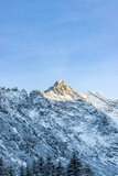 Fototapeta Góry - Sun illuminate mountain peak. Snowy mountains at sunny day. Tourism scenery. Nature mountain
