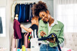 © Art_Photo - Portrait of young african american woman fashion designer stylish sitting and working with color samples.Attractive young african girl work with colorful fabrics at fashion studio