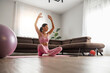 © ivanko80 - Young woman in sports clothing doing yoga while relaxing at home